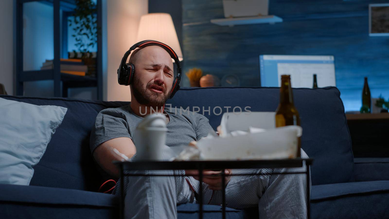 Hopeless depressed man listening sad music at headphones by DCStudio