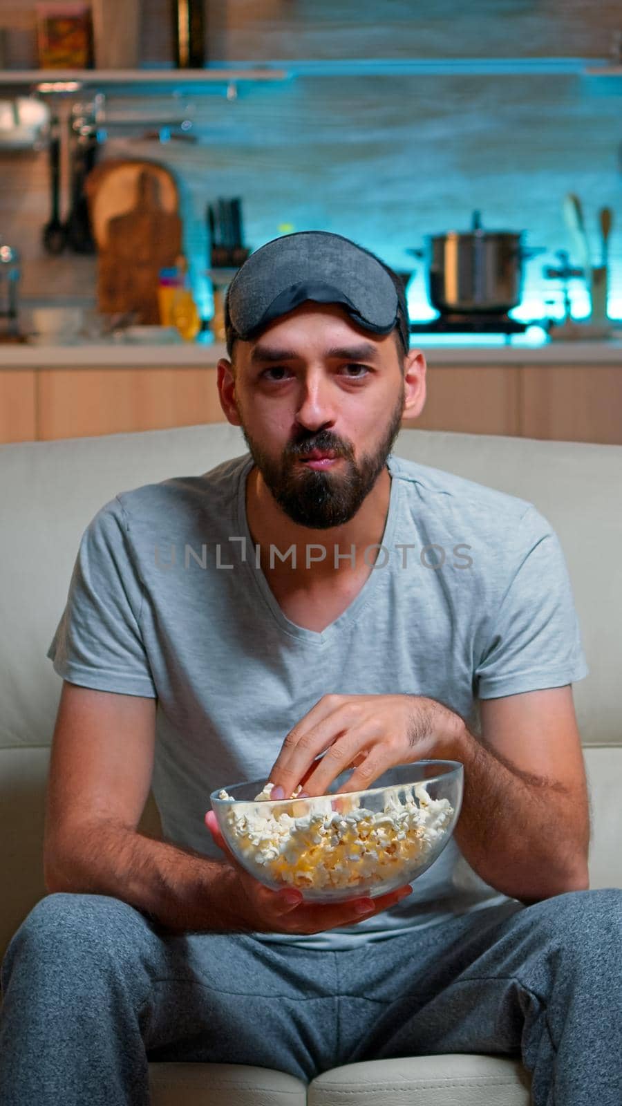 Portrait of man with beard holding popcorn bowl by DCStudio