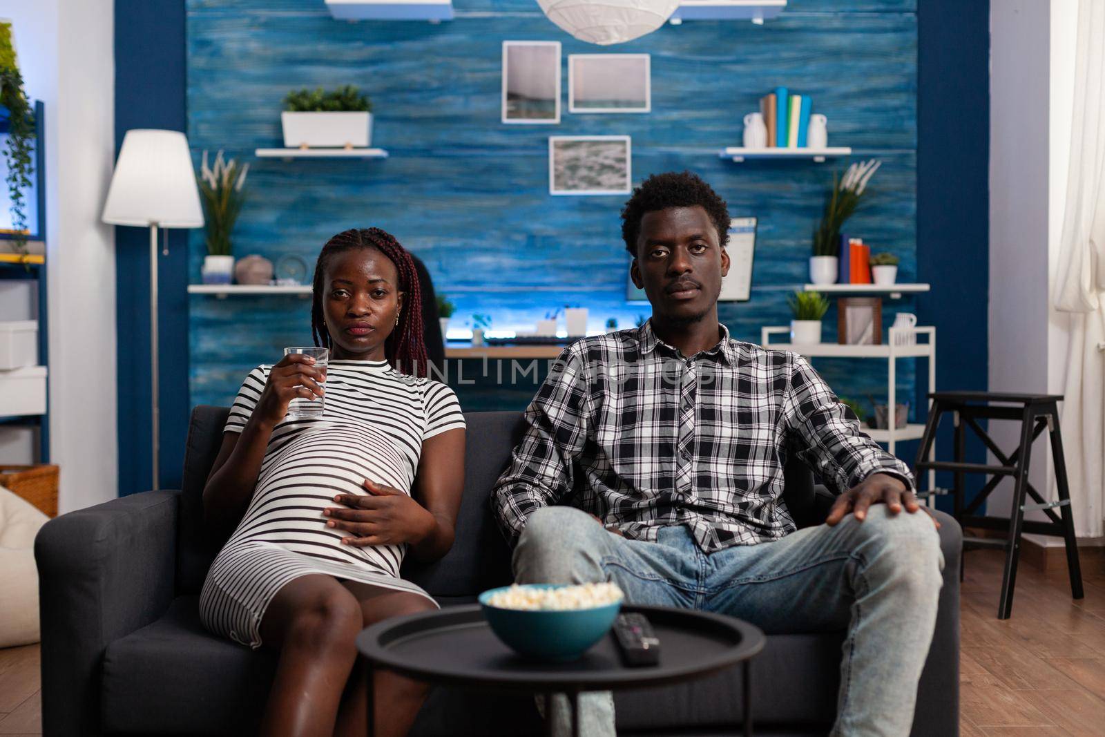 POV of black couple expecting baby watching TV by DCStudio