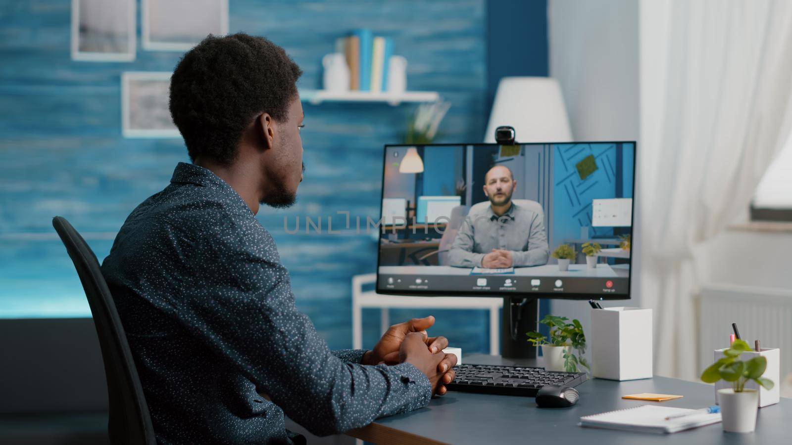 Selective focus on black guy using online conference video call talking with his work colleague, computer user on internet web chat, virtual meeting and communication