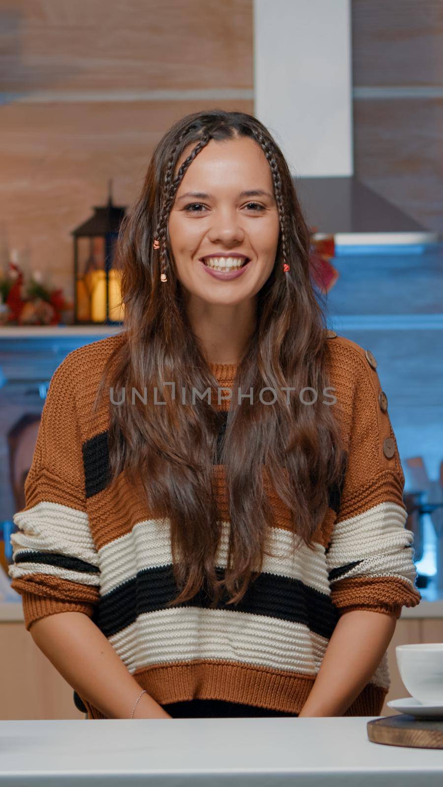 Woman talking on video call in decorated kitchen at home by DCStudio