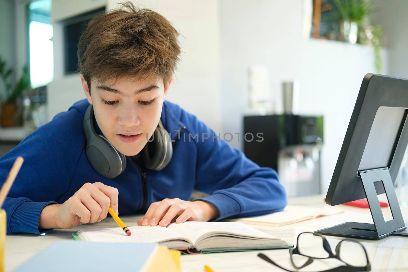 Student boy with tablet computer learning at home
 by ijeab