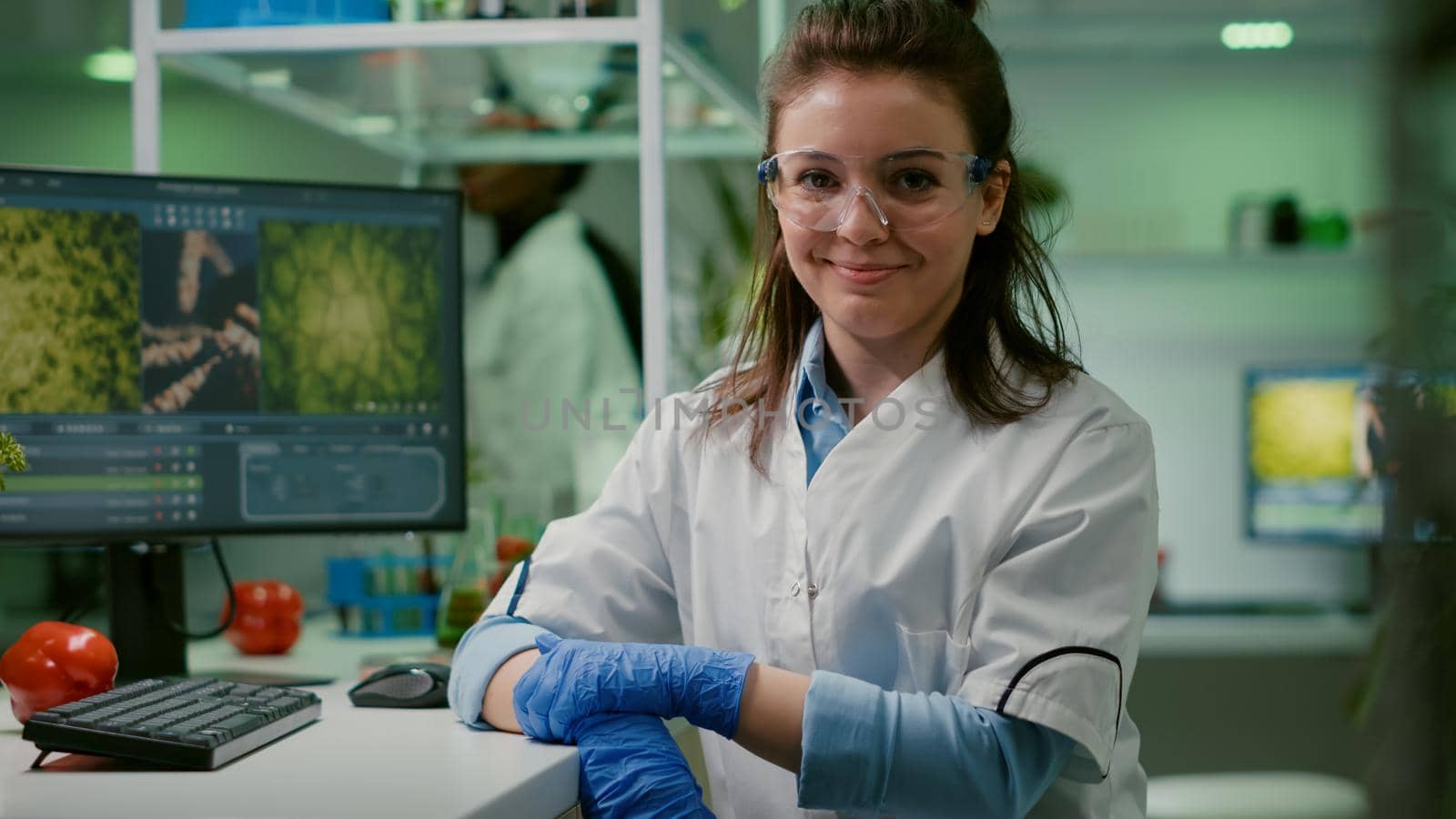 Portrait of smiling biologist woman analyzing genetically modified organism by DCStudio