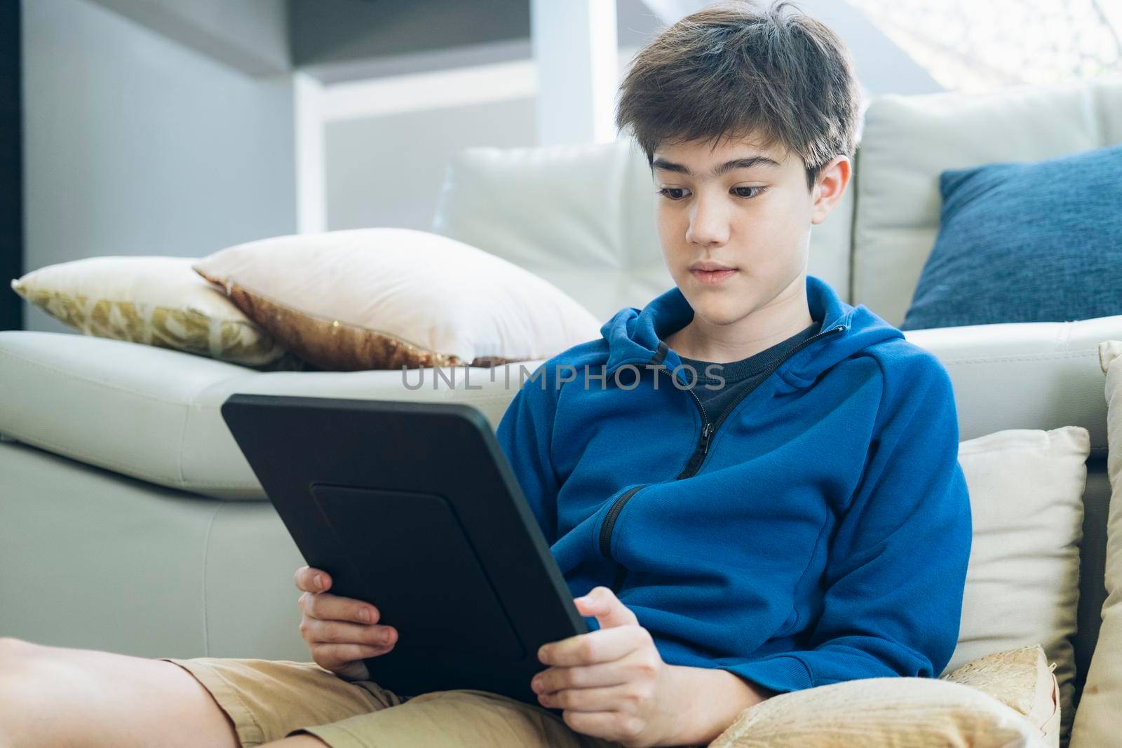 The boy using tablet to online communication at home