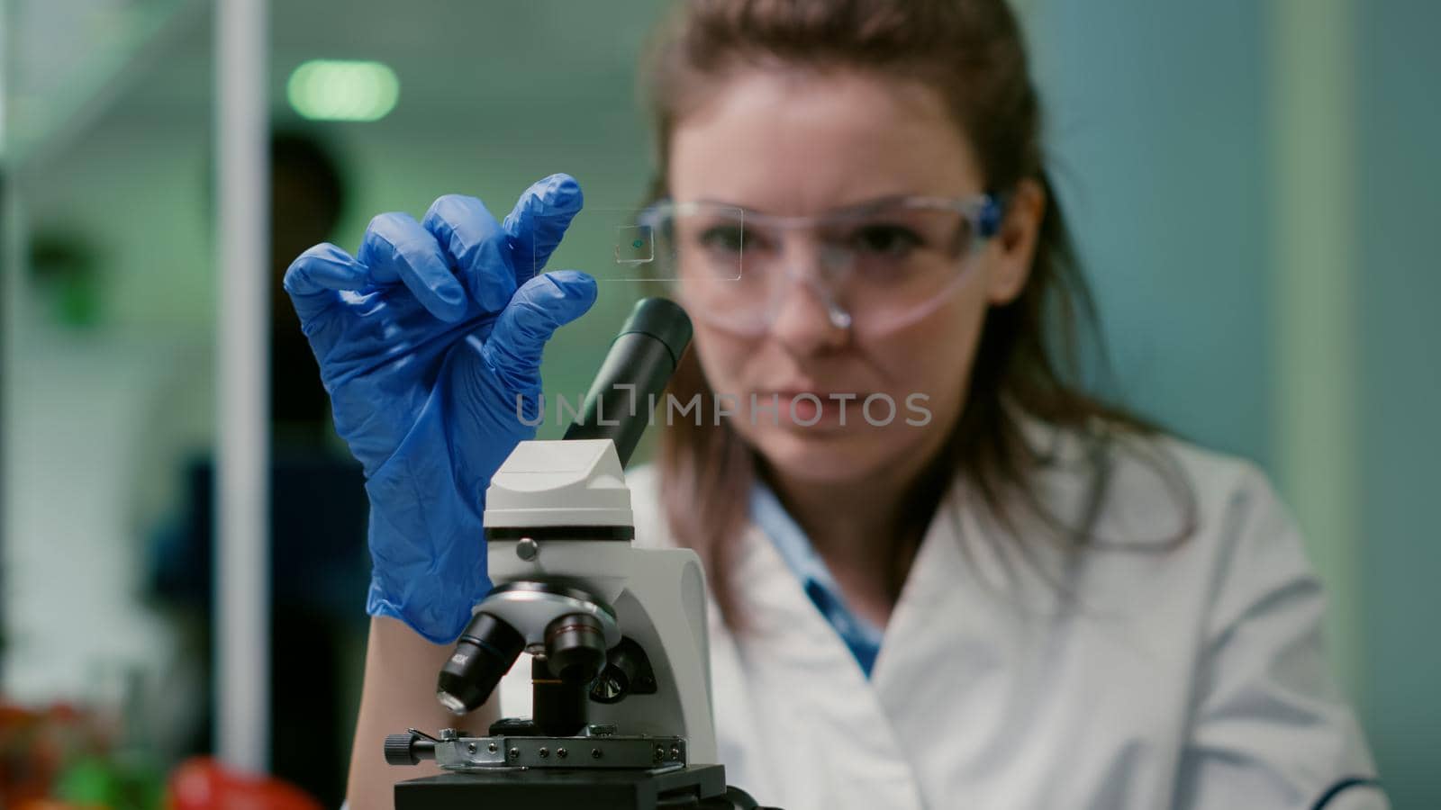 Closeup of scientist woman looking at test sample of lea by DCStudio