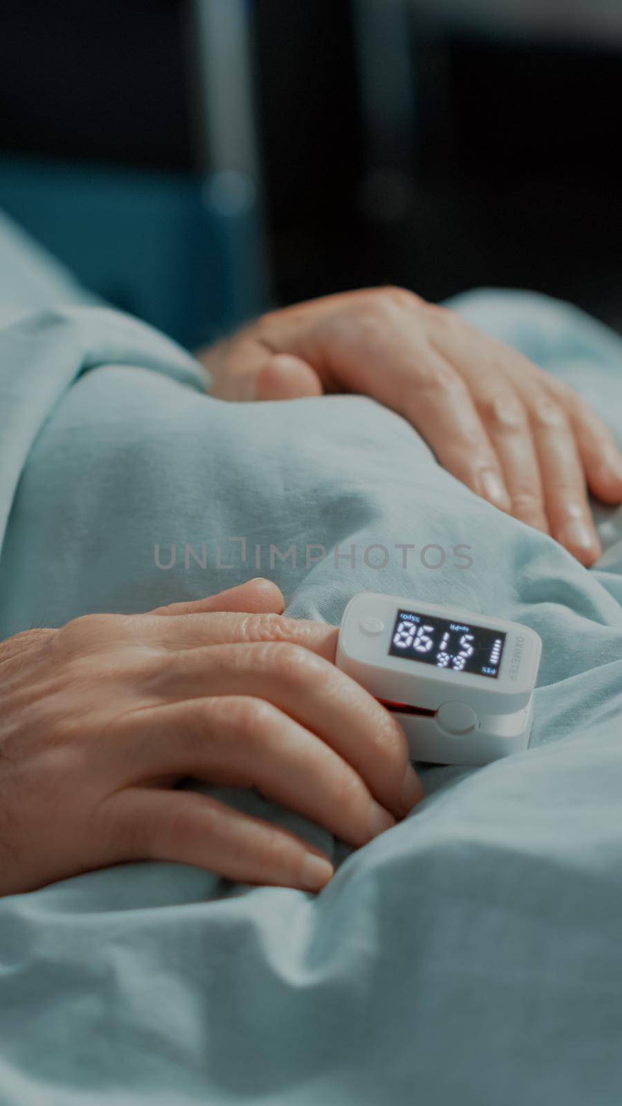 Close up of oximeter on patient in hospital ward bed by DCStudio
