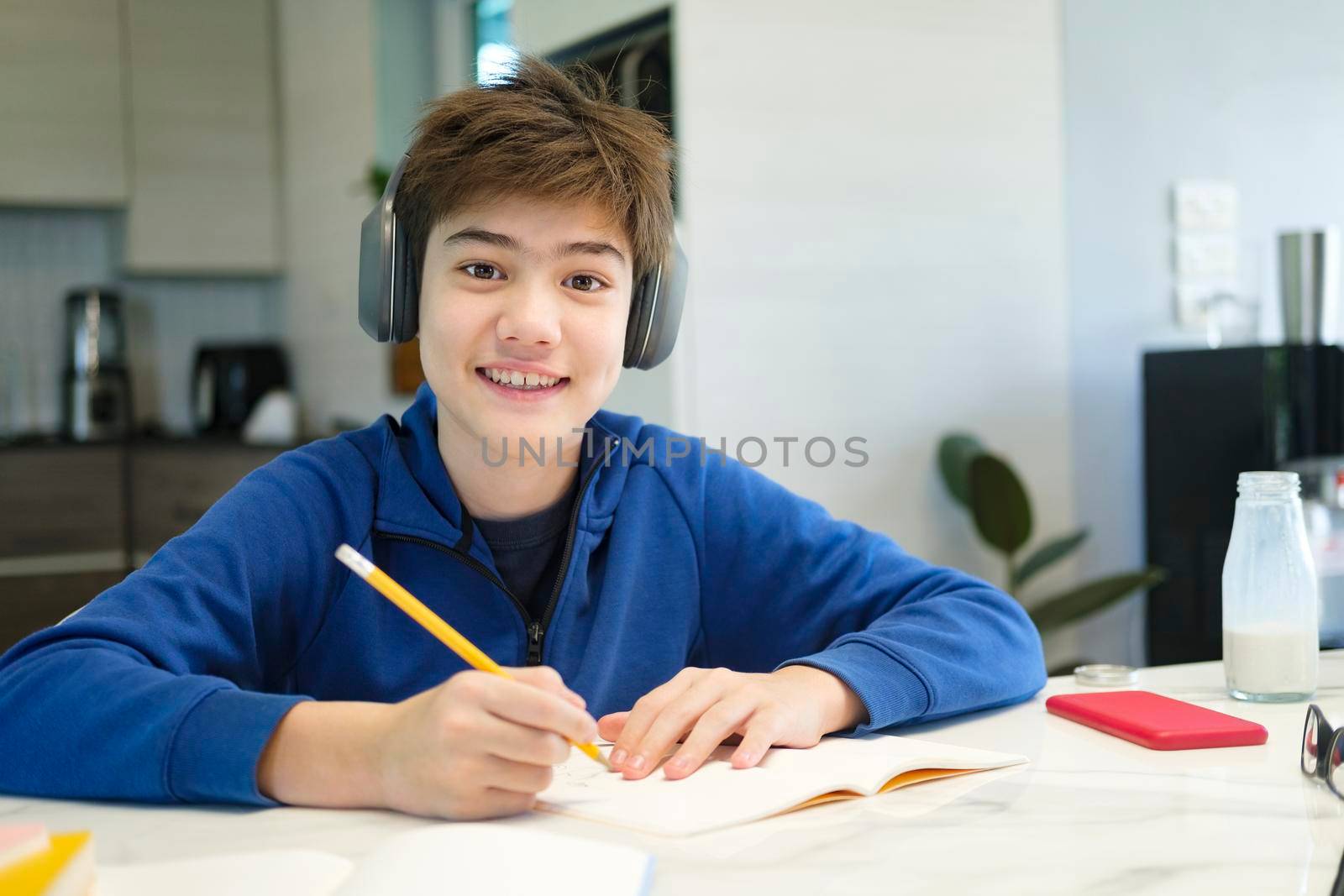 Student boy with tablet computer learning at home
 by ijeab