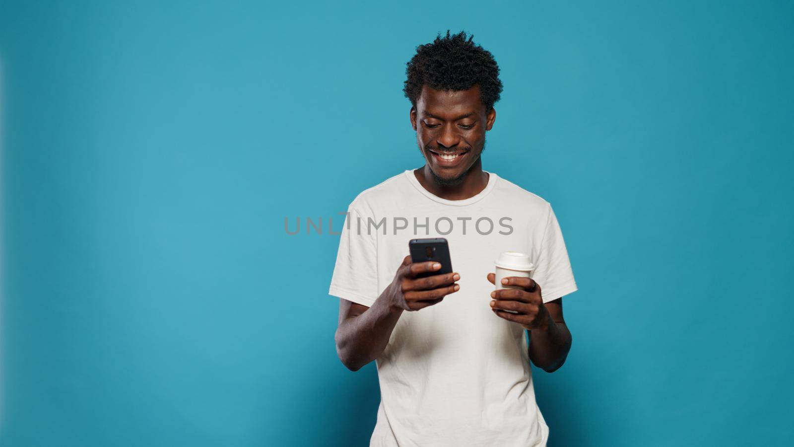Portrait of modern person looking at display on smartphone by DCStudio