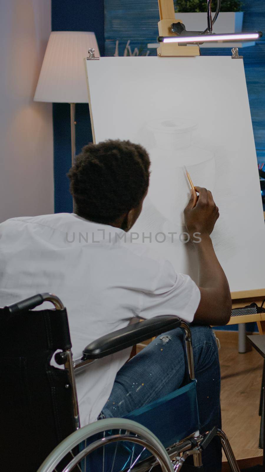Disabled african american man working on drawing of vase by DCStudio