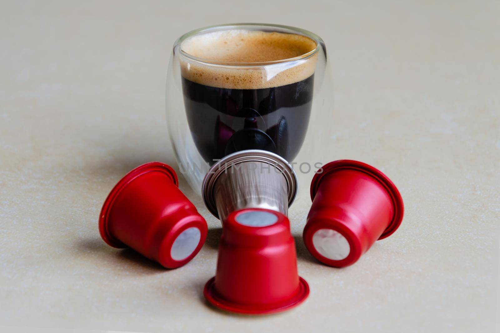 A glass of coffee and capsules for the coffee machine by ISRAFOTO