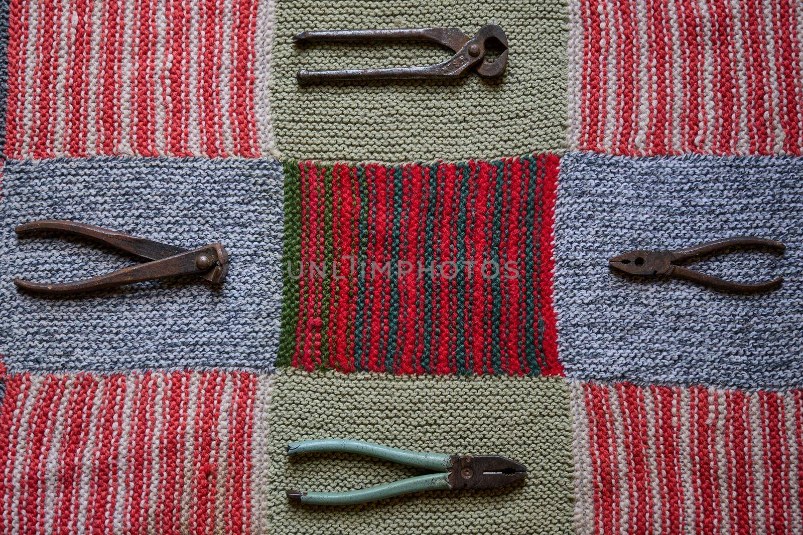 old and rusty tools on a multi-colored knitted tablecloth by ISRAFOTO