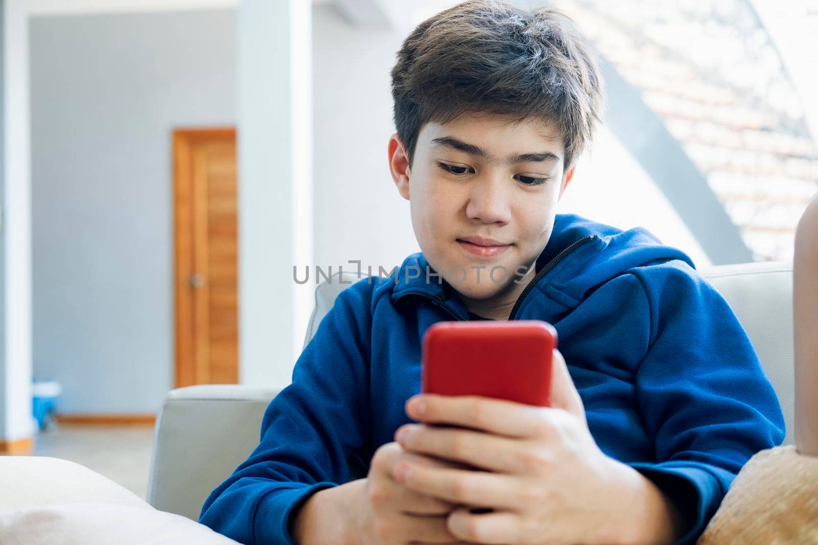 The boy playing online game on smartphone at home.