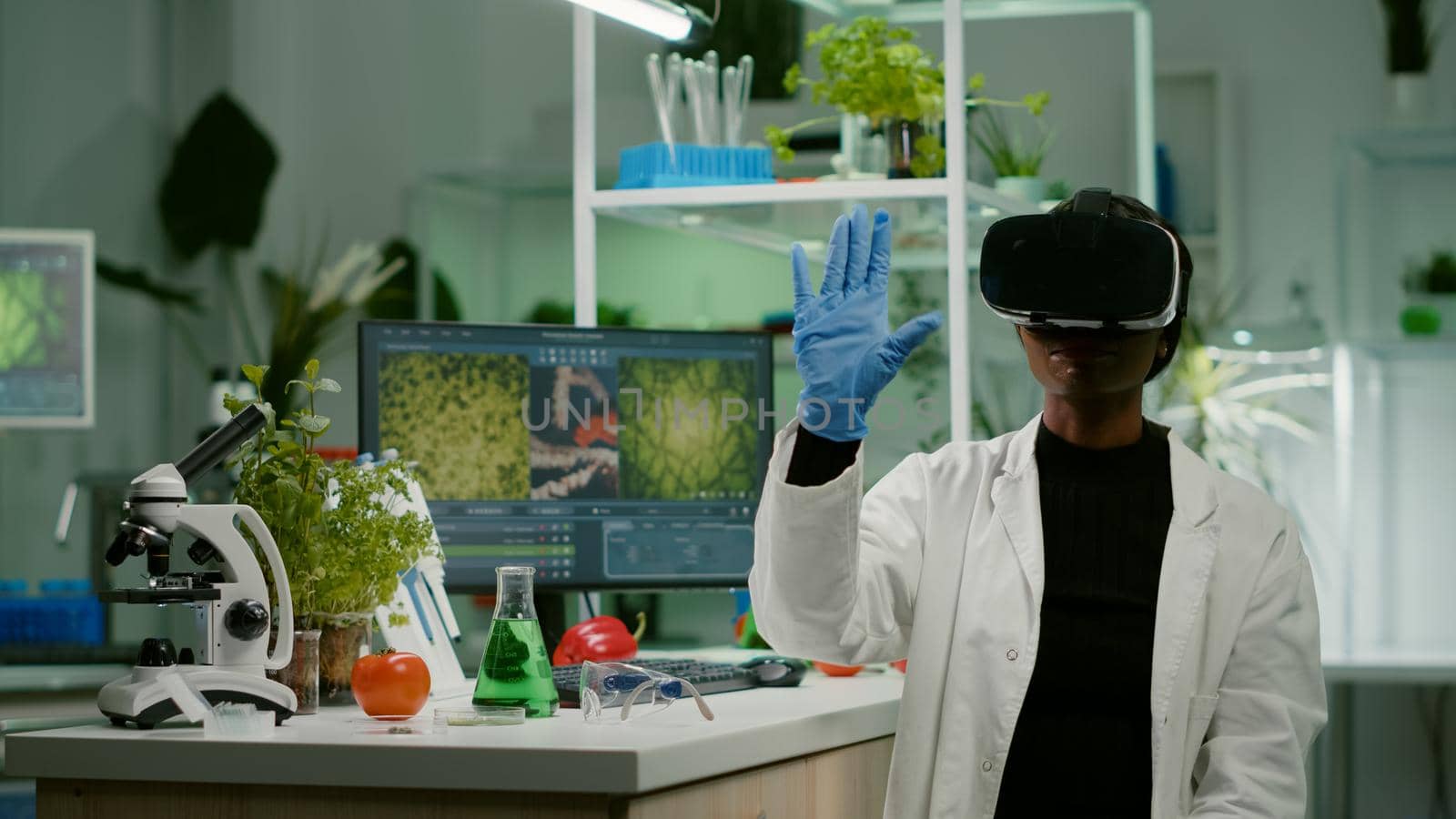 African biologist researcher with virtual reality headset researching new genetic experiment for microbiology expertise. Medical team working in pharmaceutical laboratory analyzing dna test