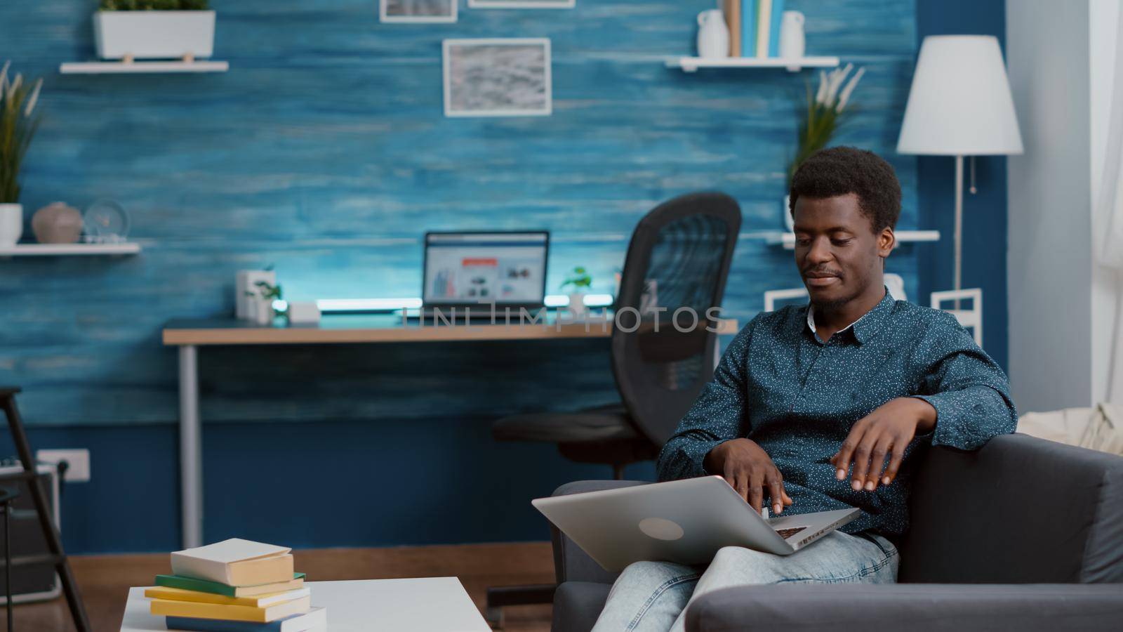 African american man browsing using laptop computer, searching social media. Authentic black freelancer entrepreneur working from home with online internet connection