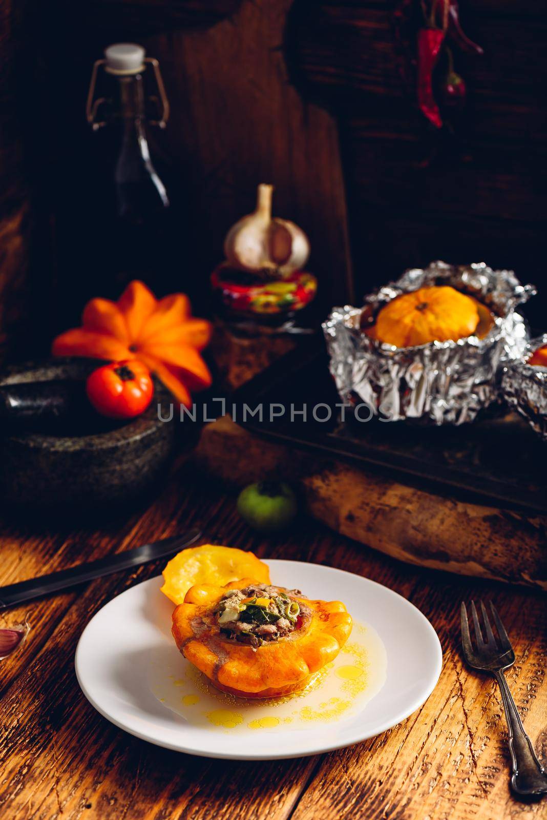 Filled pattypan squash on white plate over wooden rustic surface