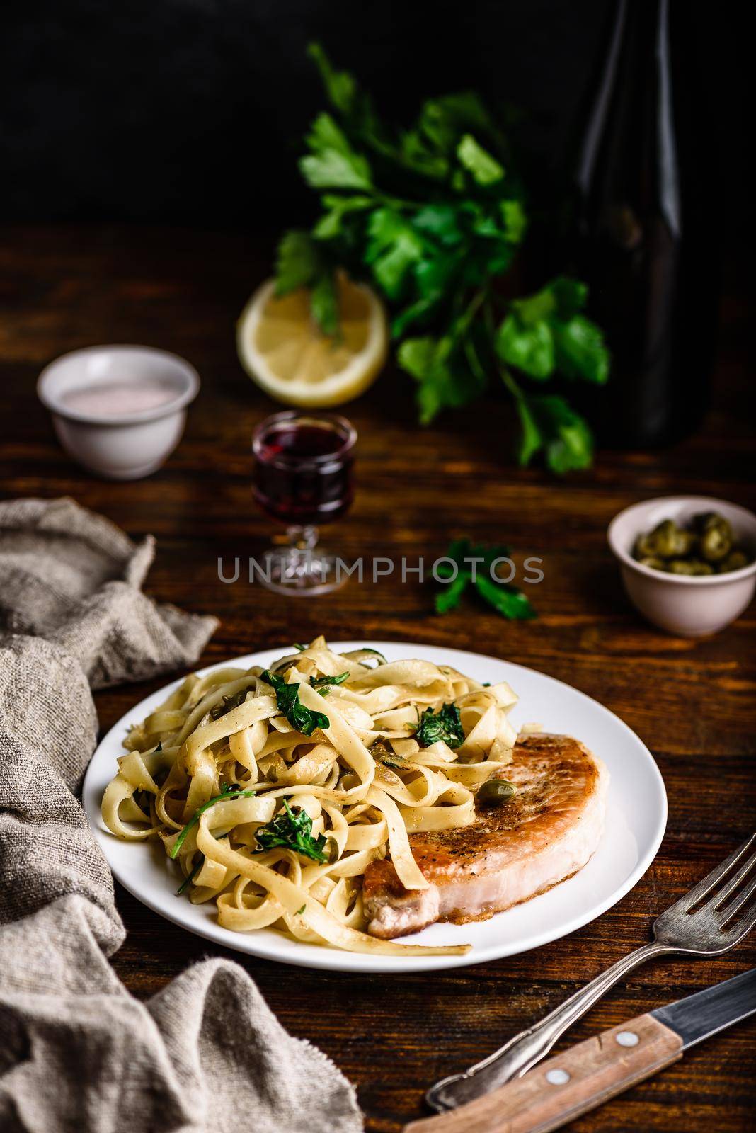 Pork chop steak and pasta with capers and lemon zest