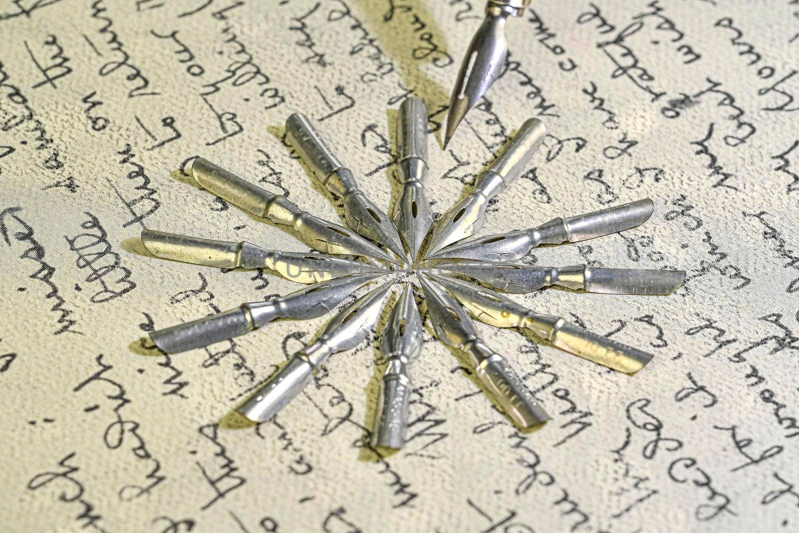 Close-up of metal nibs and old pen on vintage handwriting. Fountain pen on an ancient handwritten letter. Old story. Retro style.