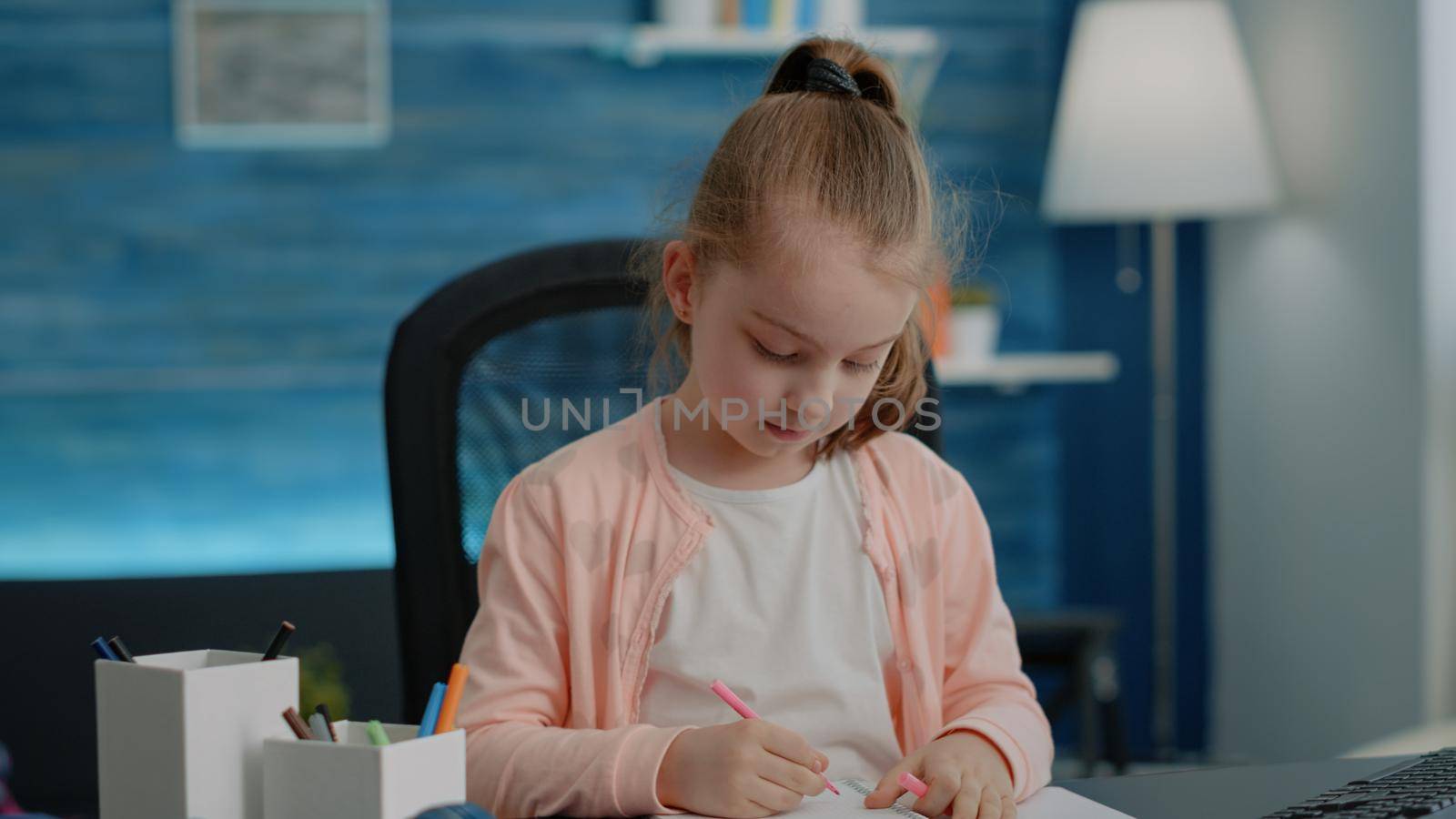 Close up of schoolgirl using pens and pencils to write on notebook by DCStudio