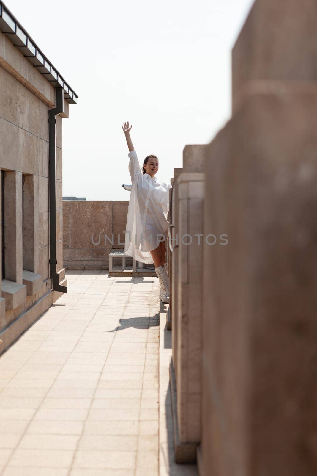 Woman tourist raising hand enjoying looking at panoramic view of beautiful metropolitan city from observation point. Landscape with urban skyscraper rooftop and aerial view. Travel concept