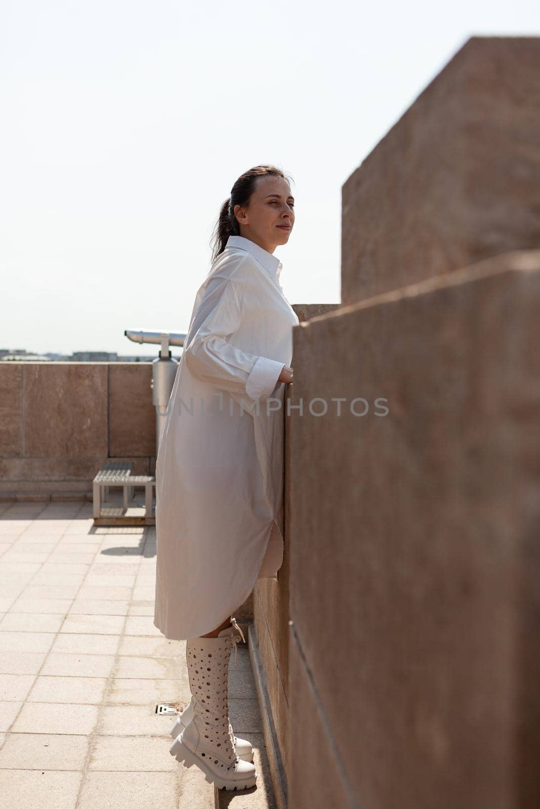 Caucasian female tourist standing on tower rooftop enjoying by DCStudio