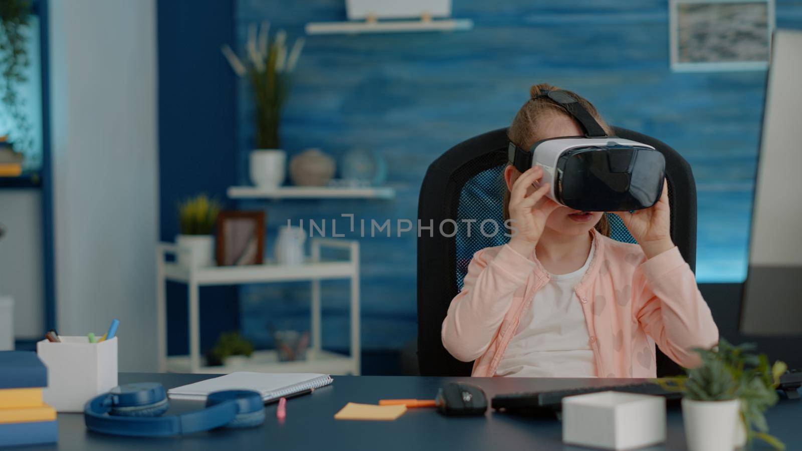 Young girl wearing vr glasses for virtual reality exercise at school. Little child using goggles with technology for online classes and lessons. Schoolgirl with headset for digital courses