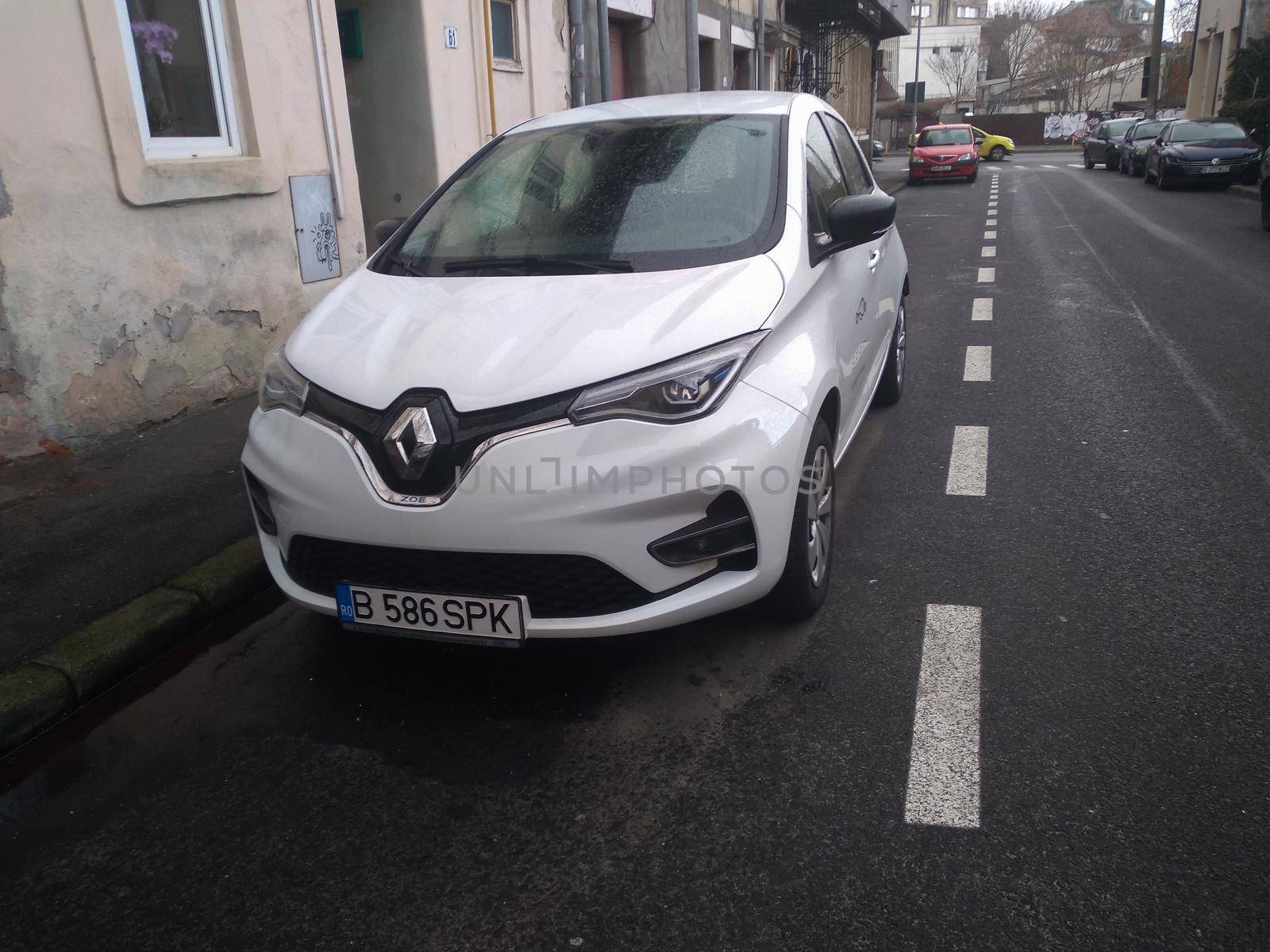 New electric car, white Spark Renault Zoe on street. Car sharing service in Bucharest, Romania, 2021 by vladispas