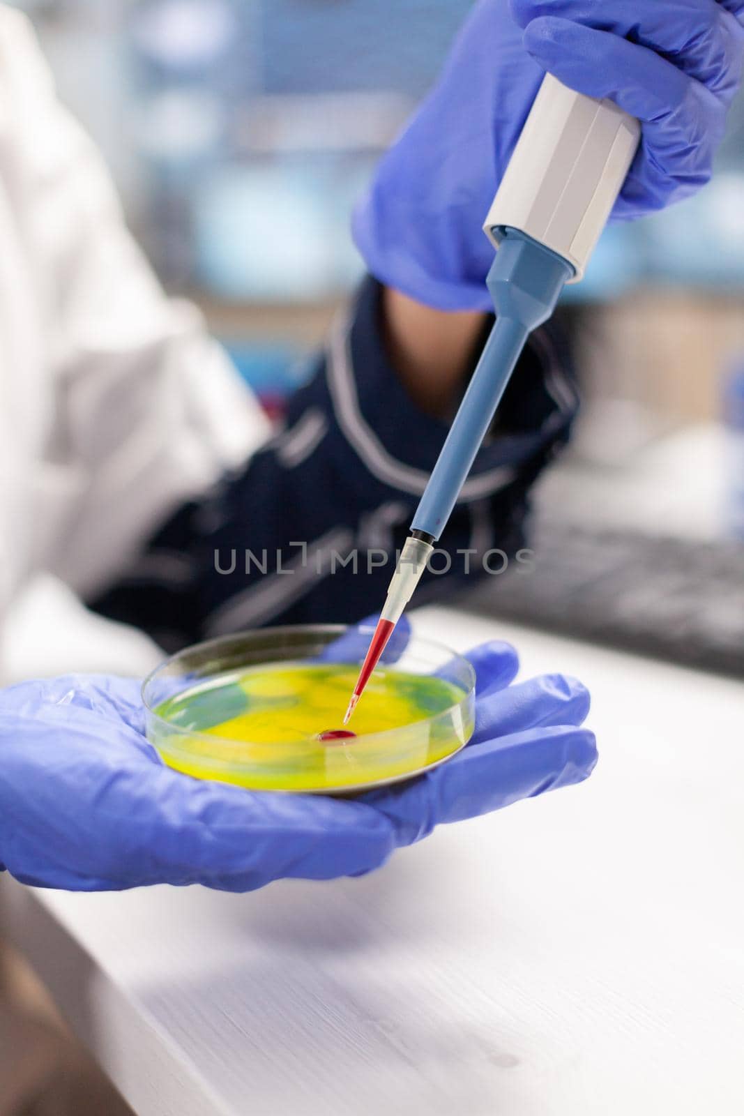 Close up of doctor dropping blood sample using micropipette in medicine lab. Medical stuff examining vaccine evolution using high tech and technology researching treatment, development.