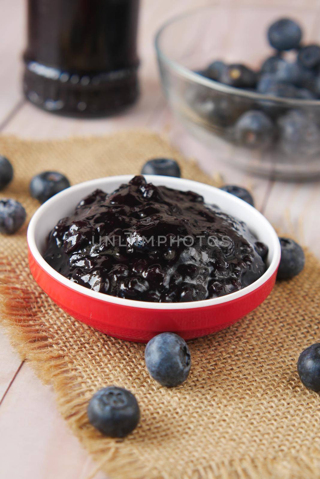 blue berry jam in container on table .