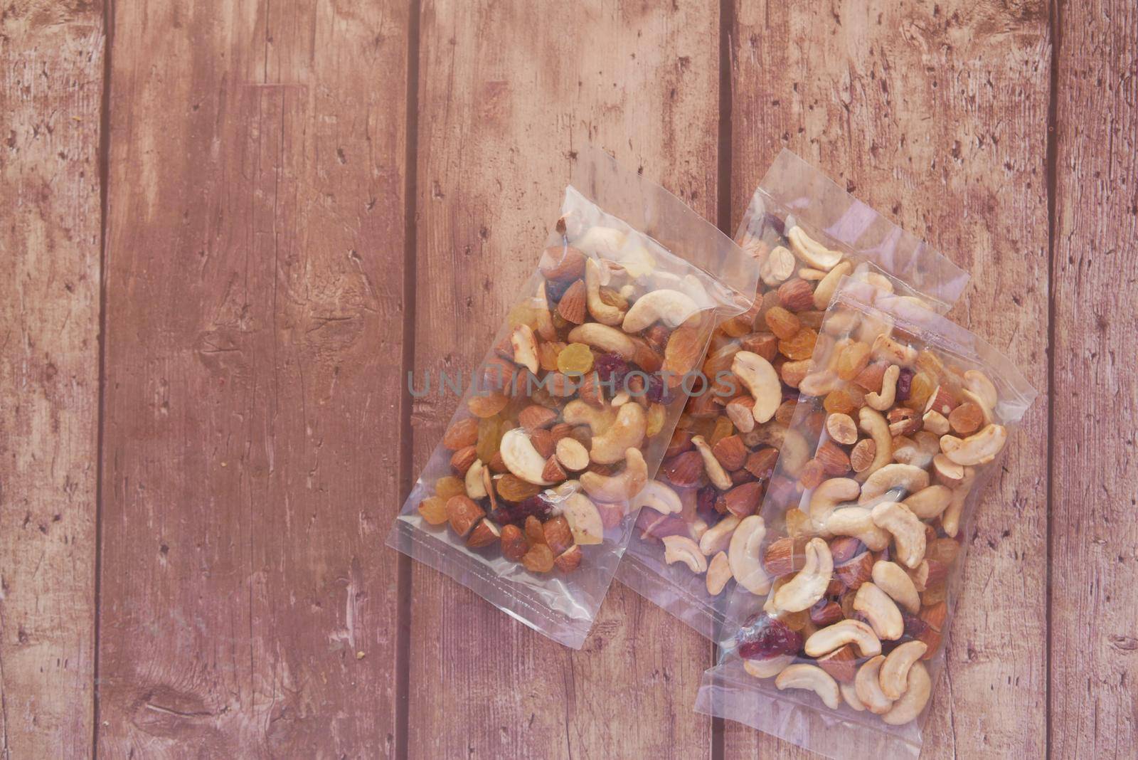 packet of mixed nuts on wooden background .