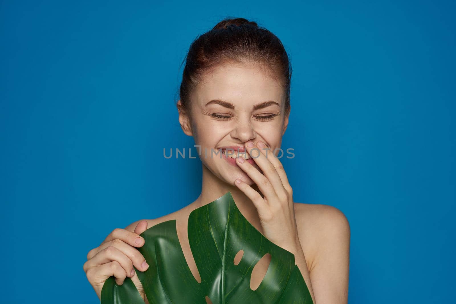 cheerful woman clean skin palm leaf cosmetics isolated background. High quality photo