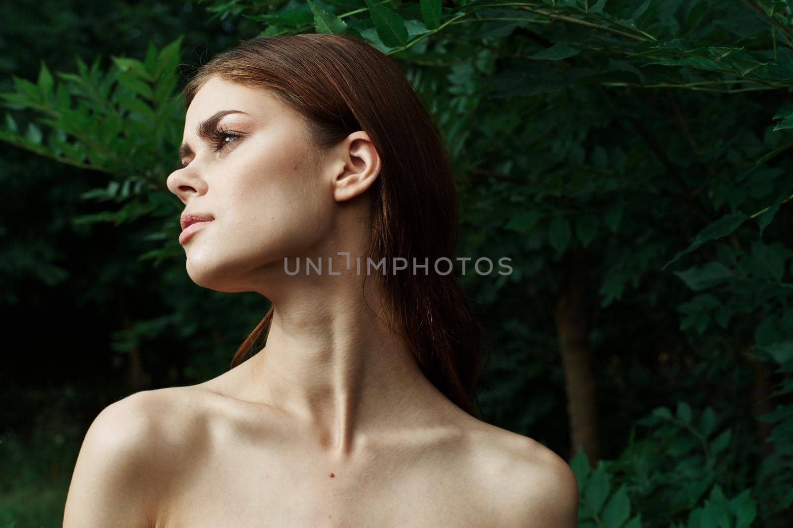 smiling woman in a field outdoors bare shoulders clear skin cropped view. High quality photo