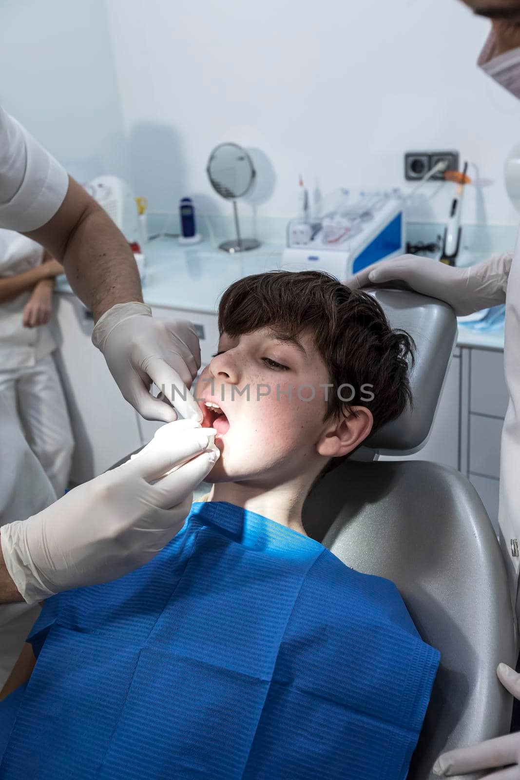 Dentist examining little boy's teeth in clinic