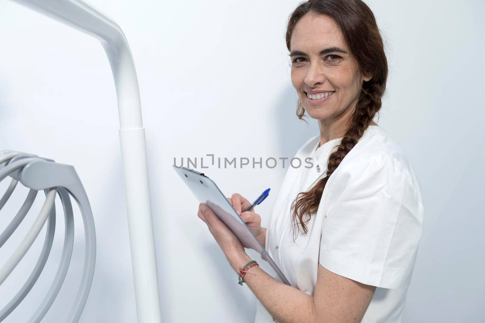 Confident experienced qualified happy smiling doctor holding clipboard with documents