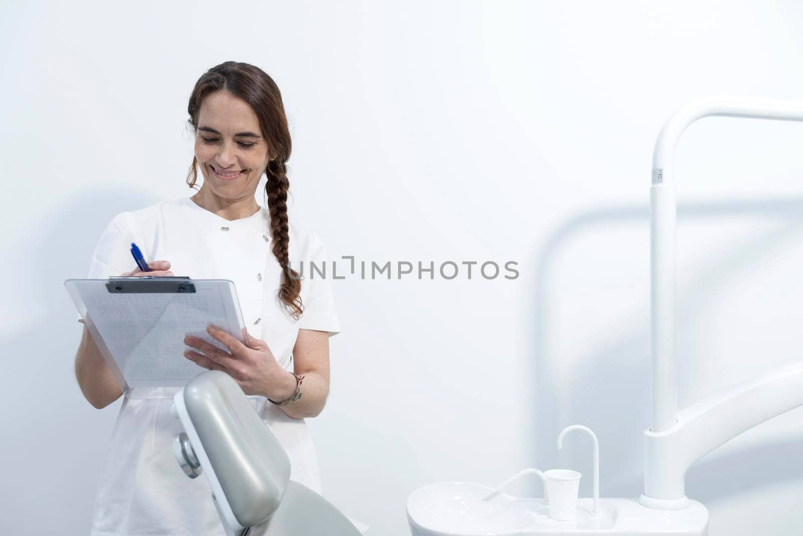 Confident experienced qualified happy smiling doctor holding clipboard with documents