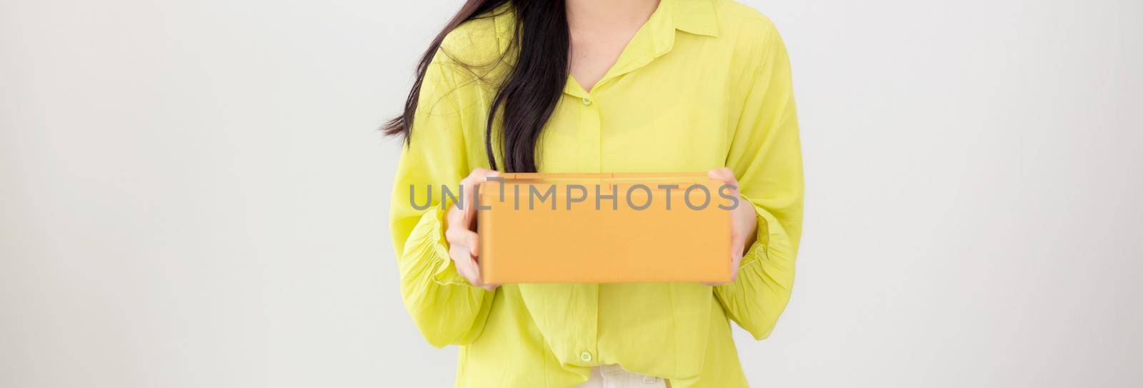 Young asian woman smiling and holding cardboard box at home, happy female carrying parcel box giving, present and gift, packaging for deliver, online shopping store and service concept.