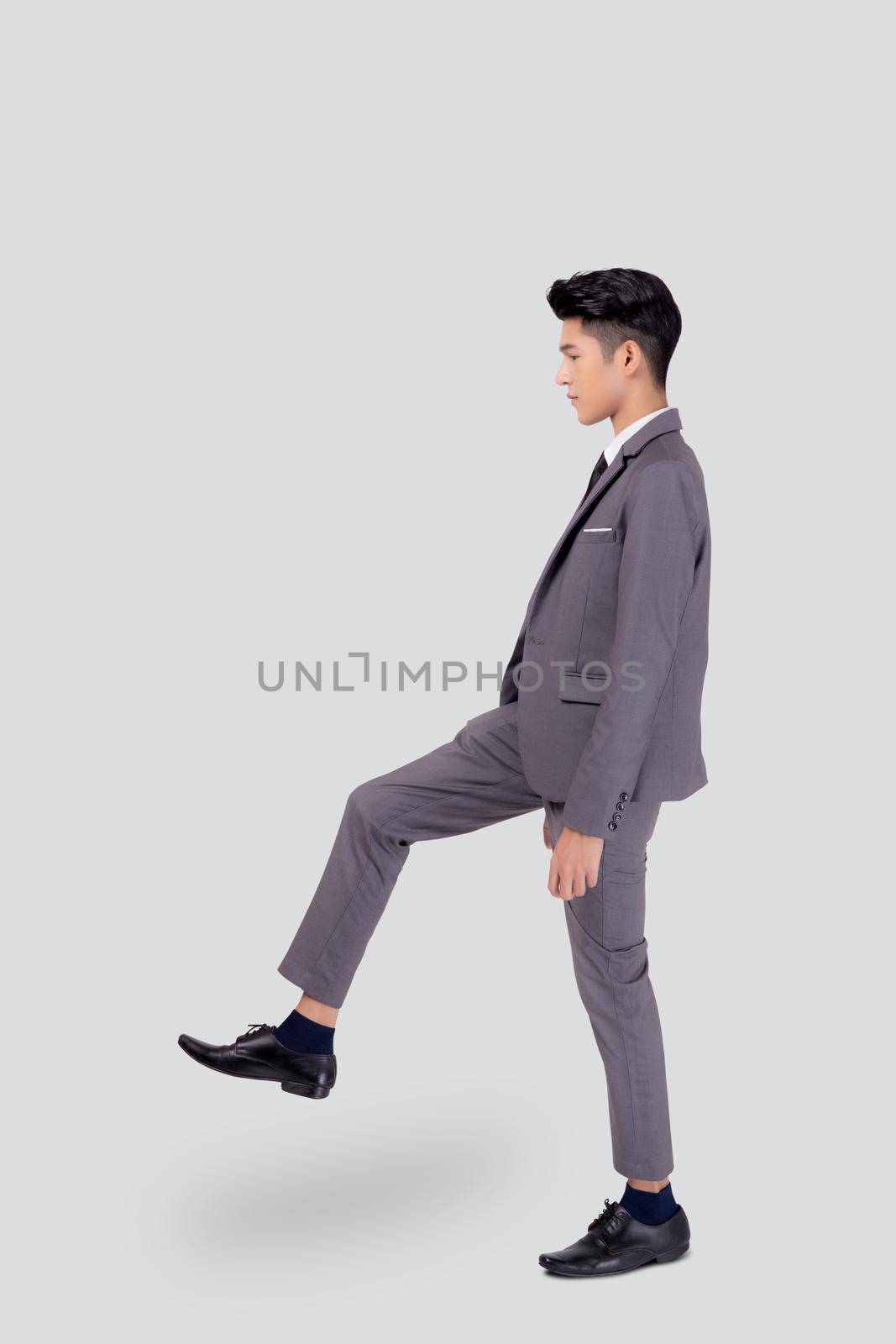Young asian business man in suit walking movement isolated on white background, portrait of executive or manager, happy businessman handsome and smart, male with confident for success in studio.
