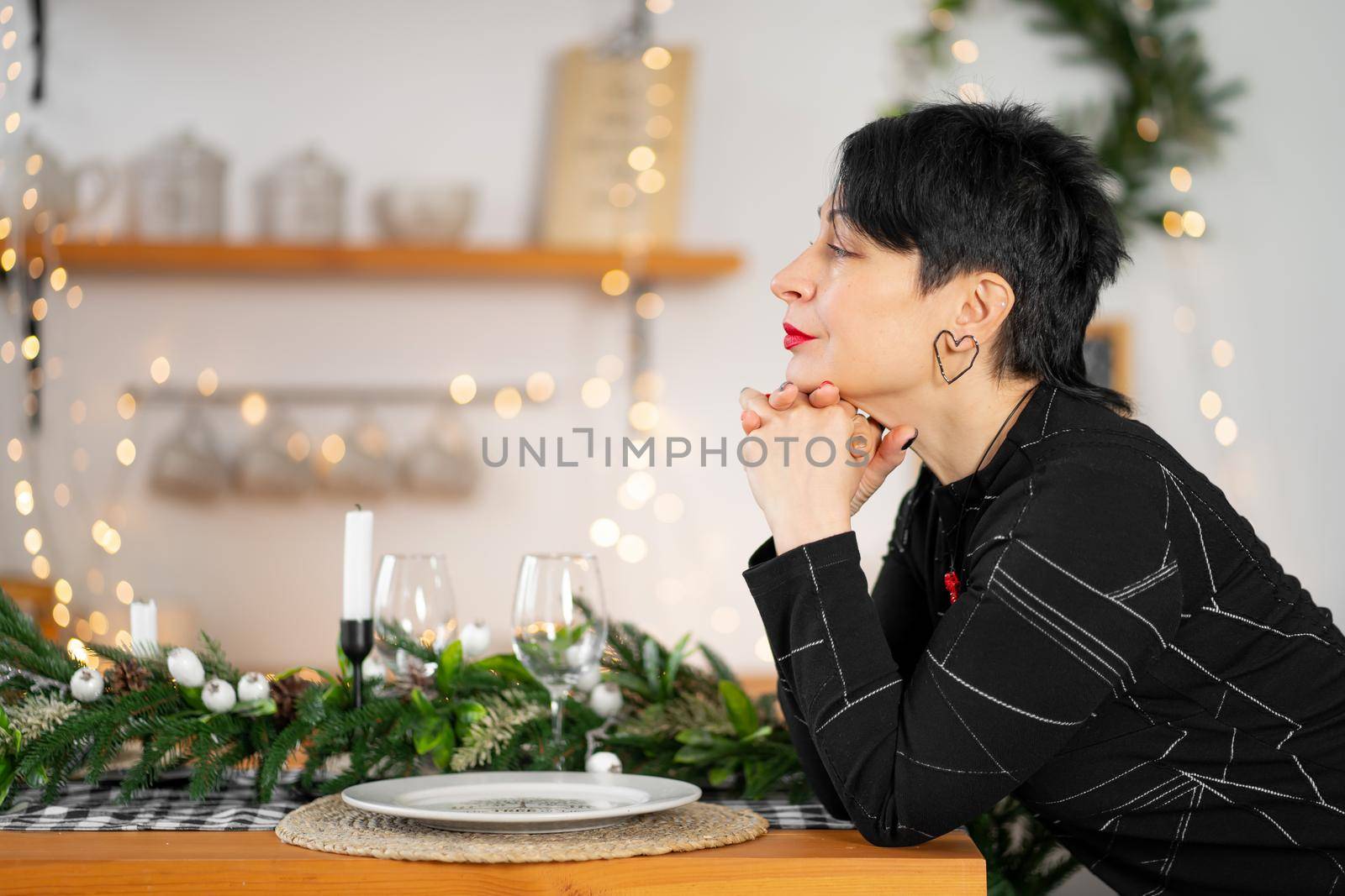 Portrait of stylish adult brunette woman making a Christmas wish at the table by Try_my_best