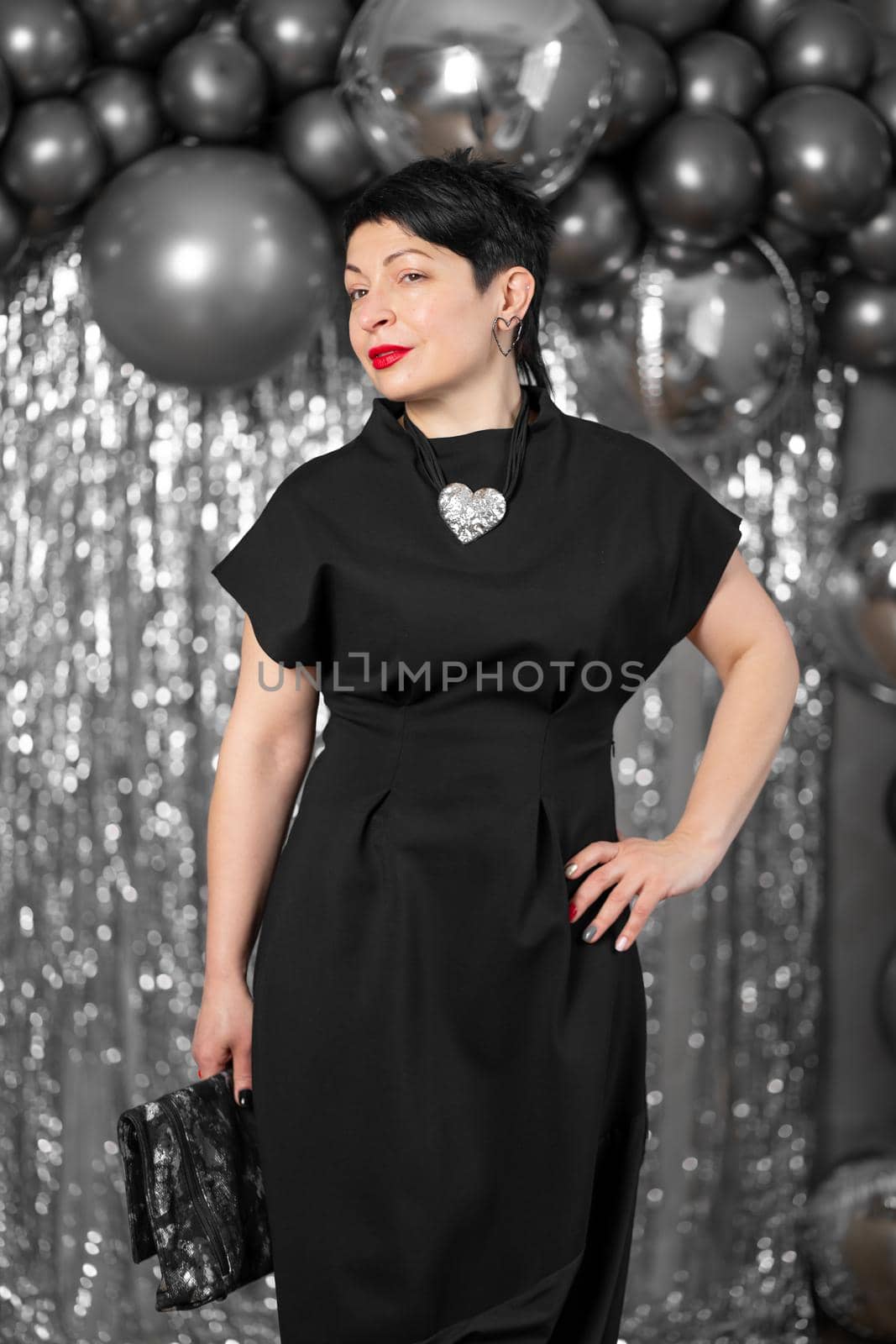 Stylish woman in elegant black dress posing on silver background. by Try_my_best