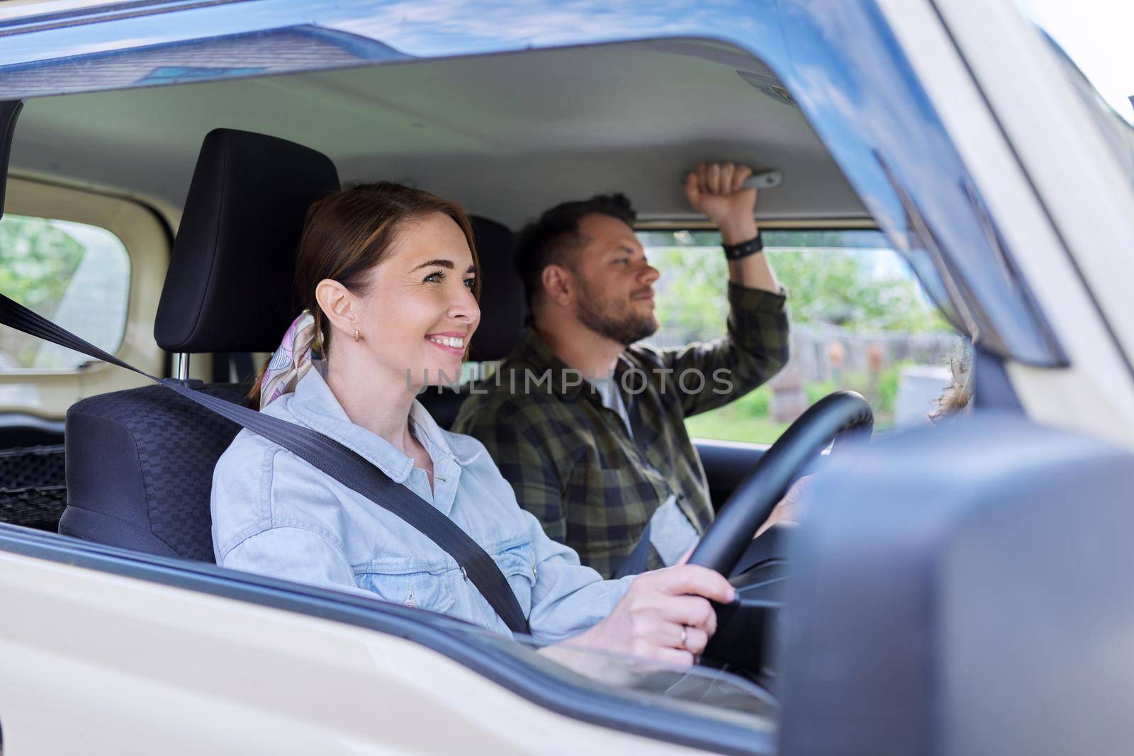 Middle age couple riding in car, woman driver man in passenger seat by VH-studio