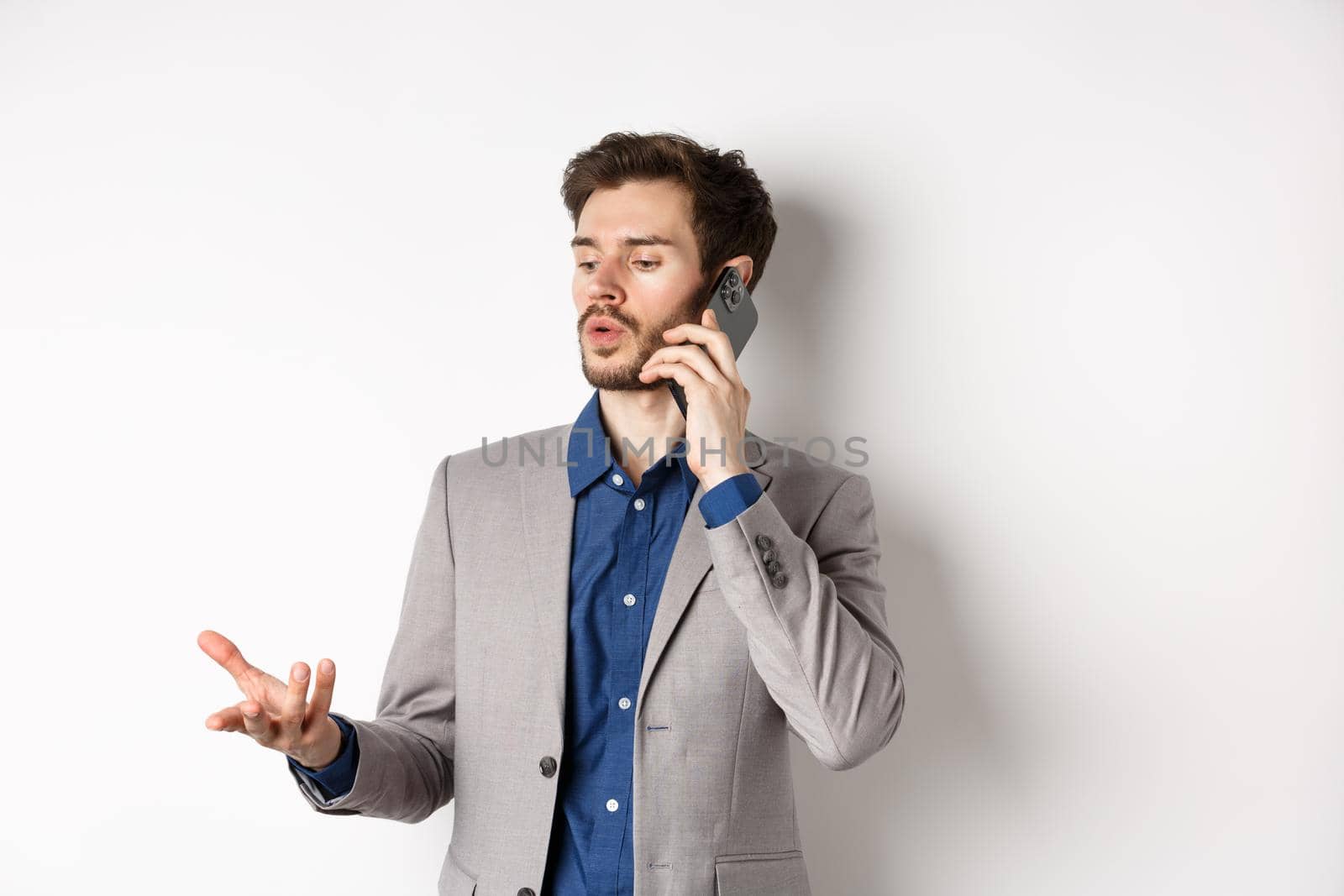 Handsome businessman having business call on phone, gesturing while talking on mobile, having conversation, white background.