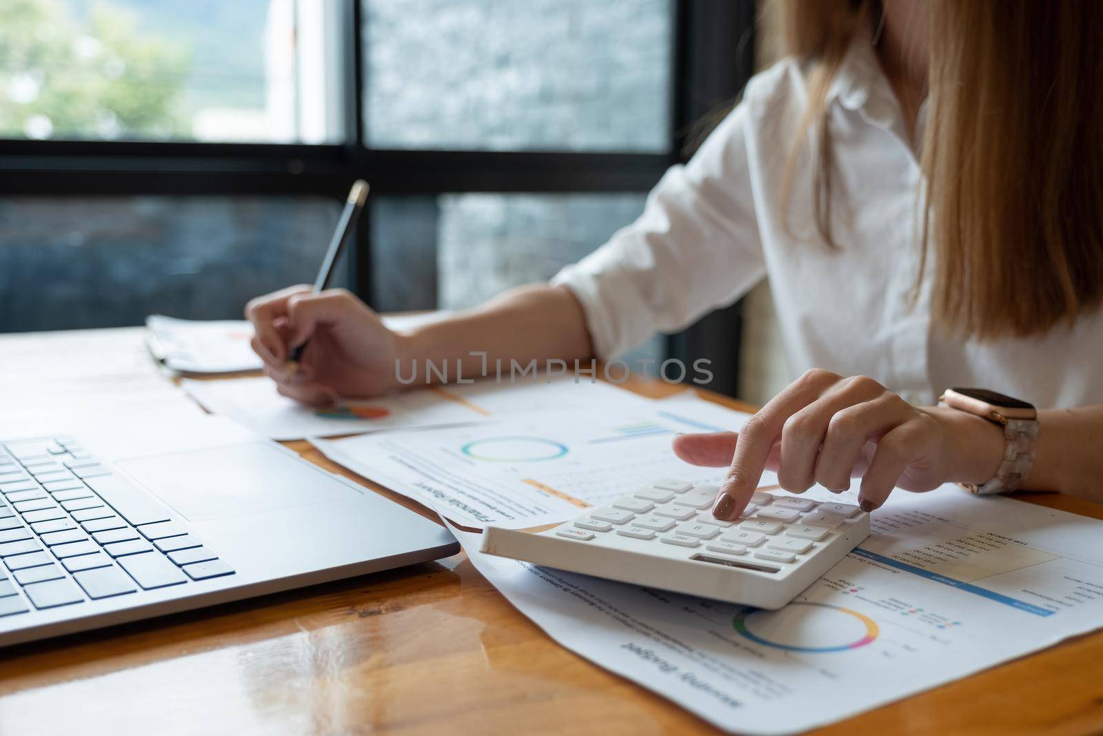 Business woman doing accounting with calculator and paperwork, financial adviser working.