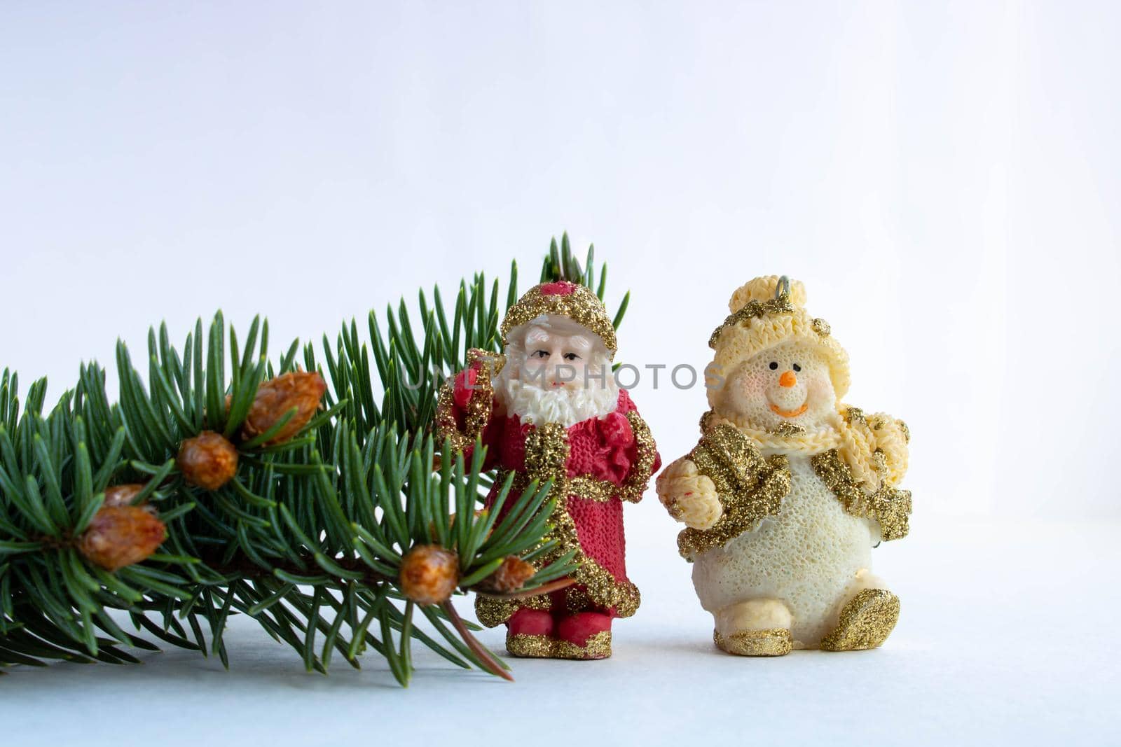 Santa Claus, a Snowman and a spruce branch with small young cones isolated on a white background.The concept of the New year and Christmas.