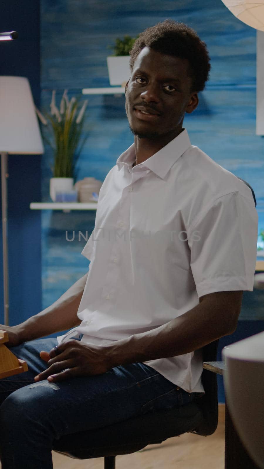 Black man in art studio preparing for creativity process designing masterpiece. African american person using pencil and tools for professional modern drawing of authentic white vase