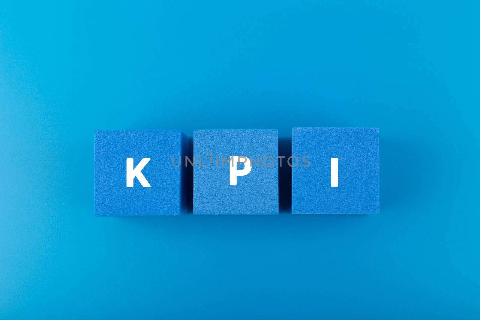 KPI letters on blue toy cubes against dark blue background with copy space by Senorina_Irina