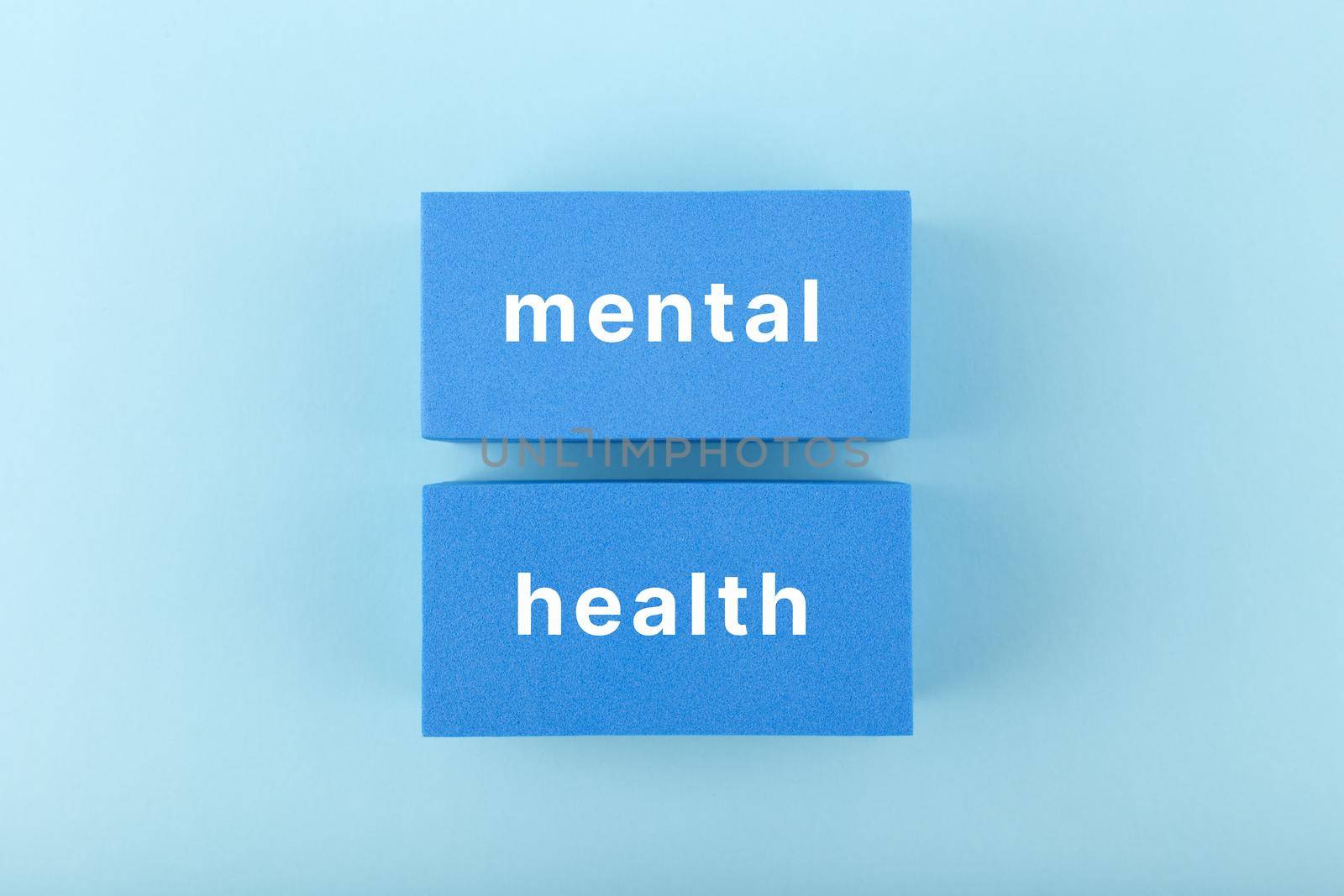 Mental health text written on dark blue rectangles in the middle of bright blue background by Senorina_Irina
