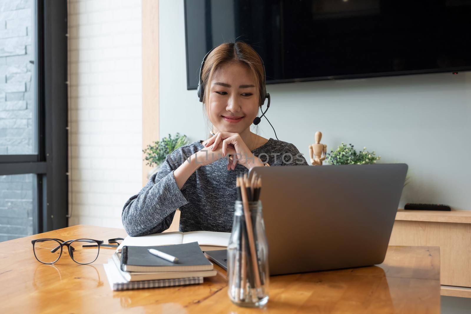 Cropped shot smiling asian woman freelancer wearing headset, communicating with client via video computer call. Millennial pleasant professional female tutor giving online language class by nateemee