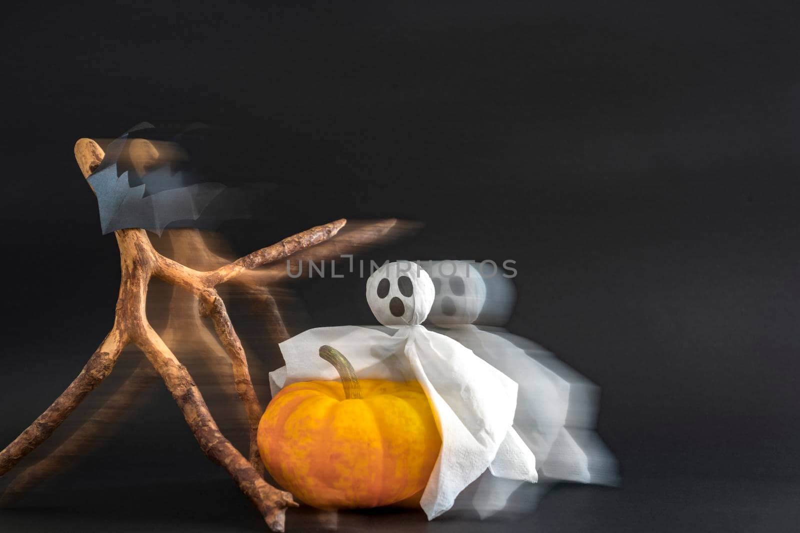 Pumpkin, ghost and bats on black background with blur effect. Copy space