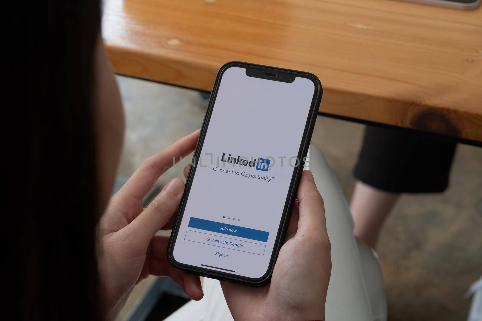 CHIANG MAI, THAILAND, OCT 10, 2021 : A women holds Apple iPhone 12 with LinkedIn application on the screen.LinkedIn is a photo-sharing app for smartphones.