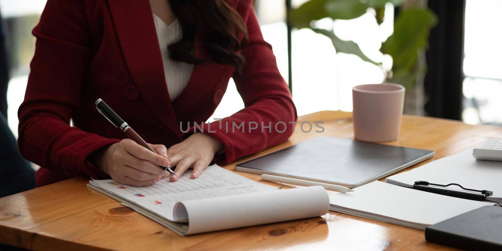 Business woman using calculator for do math finance on wooden desk in office and business working background, tax, accounting, statistics and analytic research concept. by nateemee