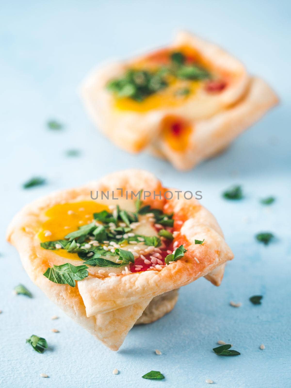 Ideas and recipes for healthy Vegan Shakshouka cups with vegan tofu eggs and turmeric yolk. Puff filo pastry,tomato and vegetable sauce and fresh green parsley. Copy space for text. Vertical.